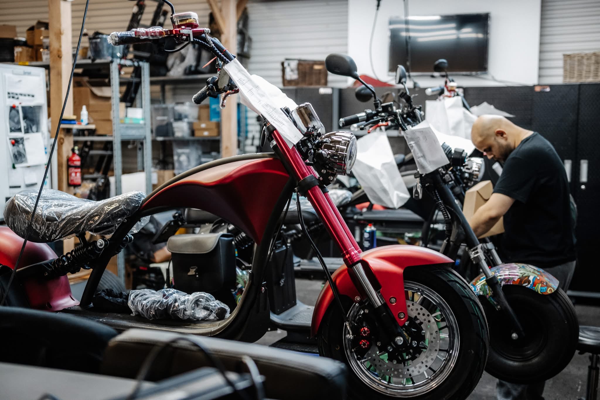 Elektroroller in der Hebebühne – Techniker justiert die Federung an einem Star-Biker Chopper für optimalen Fahrkomfort