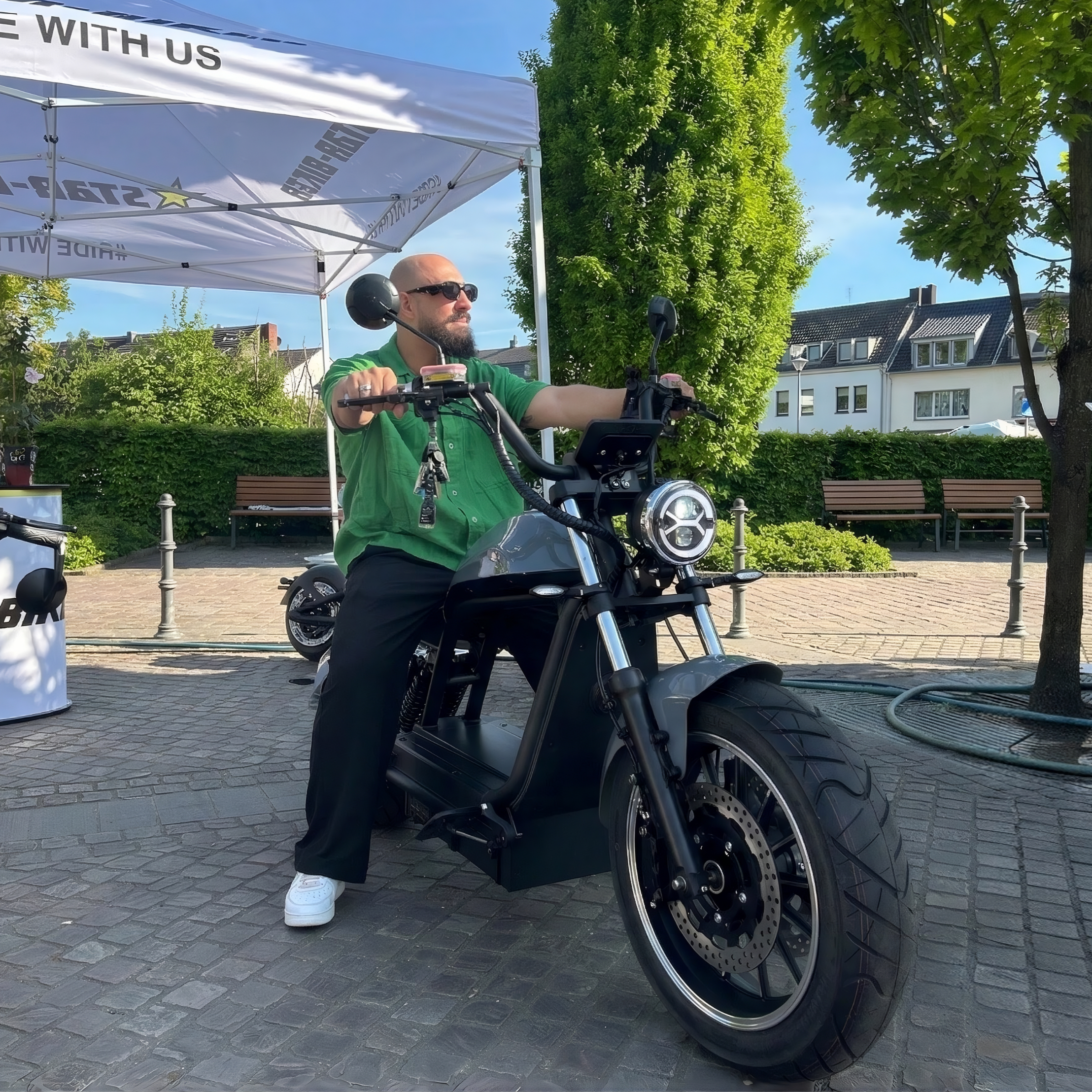 Star-Biker E-Chopper auf einem Event – Besucher testet elektrischen Chopper bei einer Elektromobilitäts-Veranstaltung
