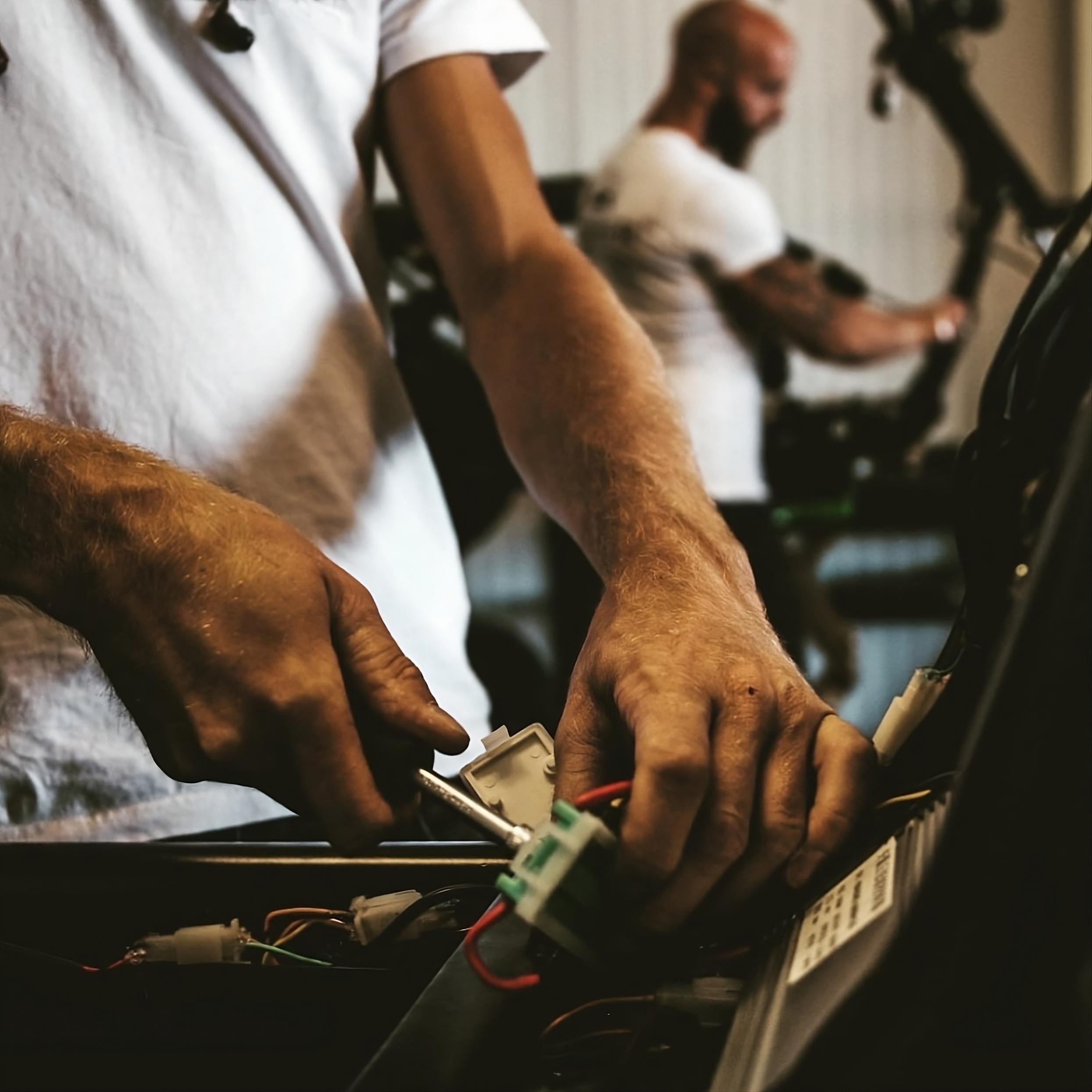 Detailaufnahme einer Reparatur am Star-Biker E-Chopper – Techniker verbindet elektrische Komponenten während Wartungsarbeiten